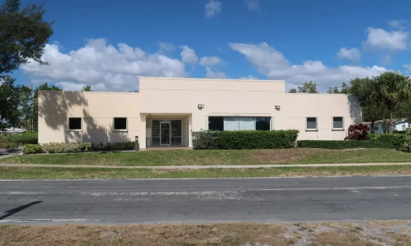 Internal medicine office in Boynton Beach with beige stucco exterior and glass entry