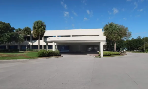 Wellington internal medicine clinic exterior with covered drop-off and palm-lined landscaping.