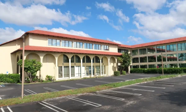 Lake Worth internal medicine office with arched walkways, red tile roof, and empty parking lot